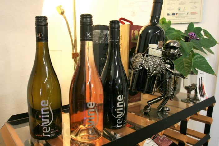 Ve vinétéce Dobrý ročník 33 prodáváme i moderní nealkoholická vína značky Revine. V pozadí je vinař neboli jedinečný stojánek na víno, který potěší každého milovníka vína.